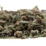 A pile of dried greenish brown thca trim hemp flower buds with a frosty surface from mega gummie bearz wholesale