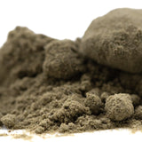 A mound of coarse earthy brown mendo breath thca kief with clumped granular textures from cult classic hemp flower