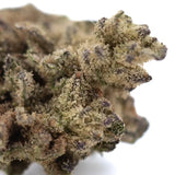 A dense money ball’s hemp flower with green and brown hues and frosty trichomes from gary poppins greenhouse smalls