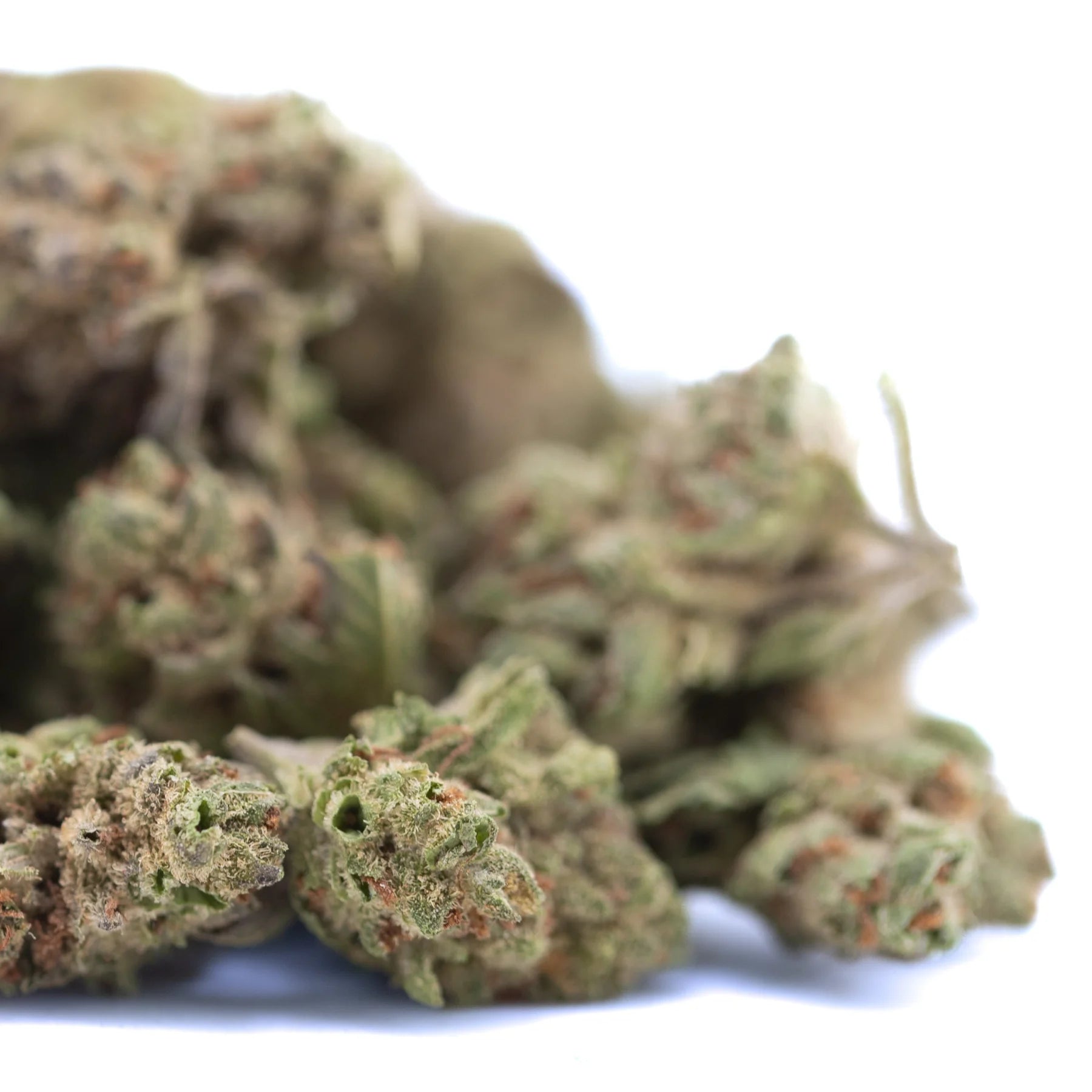 A pile of moroccan peach hemp flower greenhouse smalls with green brown hues and fine trichomes for wholesale use