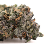 Mountain huckleberry indoor thca hemp flower with frosty deep green and purple buds accented by orange pistils and trichomes