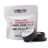 Black cylindrical container of og pineapple thca budder wax with white label and light-colored dab of hemp flower concentrate