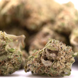 Green and brown peach pie thca smalls hemp flower greenhouse buds with frosty textured surface close up view