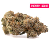 A dense resinous peach rainbow indoor thca flower bud with green brown and orange hues covered in fine trichomes