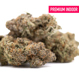 Premium indoor thca flower featuring dense frosty buds with green brown and orange hues from sour peach indoor cultivation
