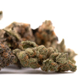 A dense textured pez indoor thca flower cannabis bud with green and brown hues covered in fine trichomes