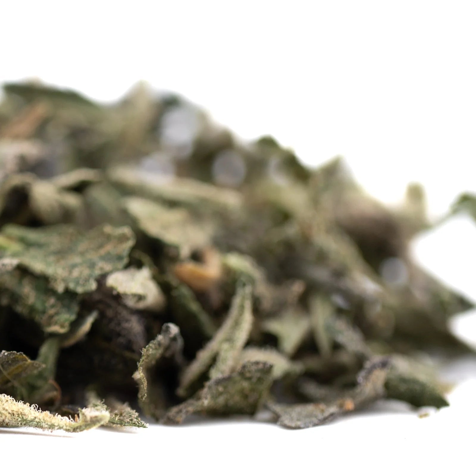 Pile of green dried mint leaves from Pineapple Express THCa trim hemp flower