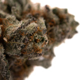 Close-up of dense rozay cake cannabis bud with trichomes and orange pistils for Poppin Bottlez #2 premium THCa flower