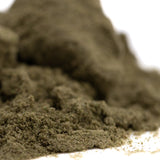 A mound of fine dark greenish brown pound town thca kief with a granular surface resembling jet fuel caramel apple