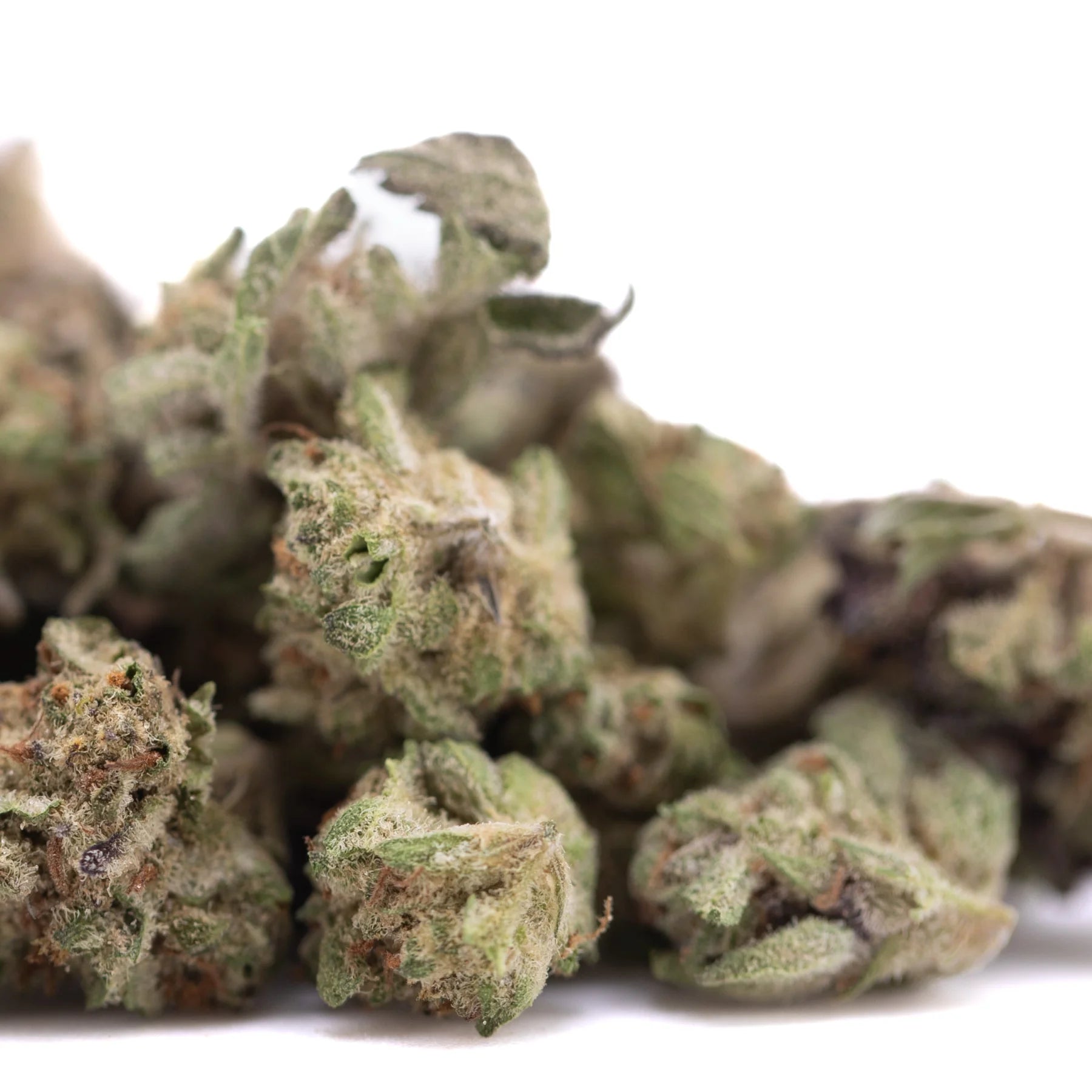 A pile of purple pop rocks hemp flower greenhouse smalls with green and brown buds covered in fine trichomes
