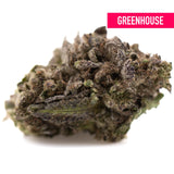 A dense purple wedding cake’s greenhouse thca flower with green and purple hues covered in resinous trichomes