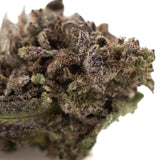 A dense purple wedding cakes cannabis bud with green and purple hues covered in trichomes greenhouse thca flower