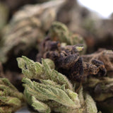 Dense green rna cbd hemp flower bud with frosty white trichomes and dark brown pistils in full-term smalls size