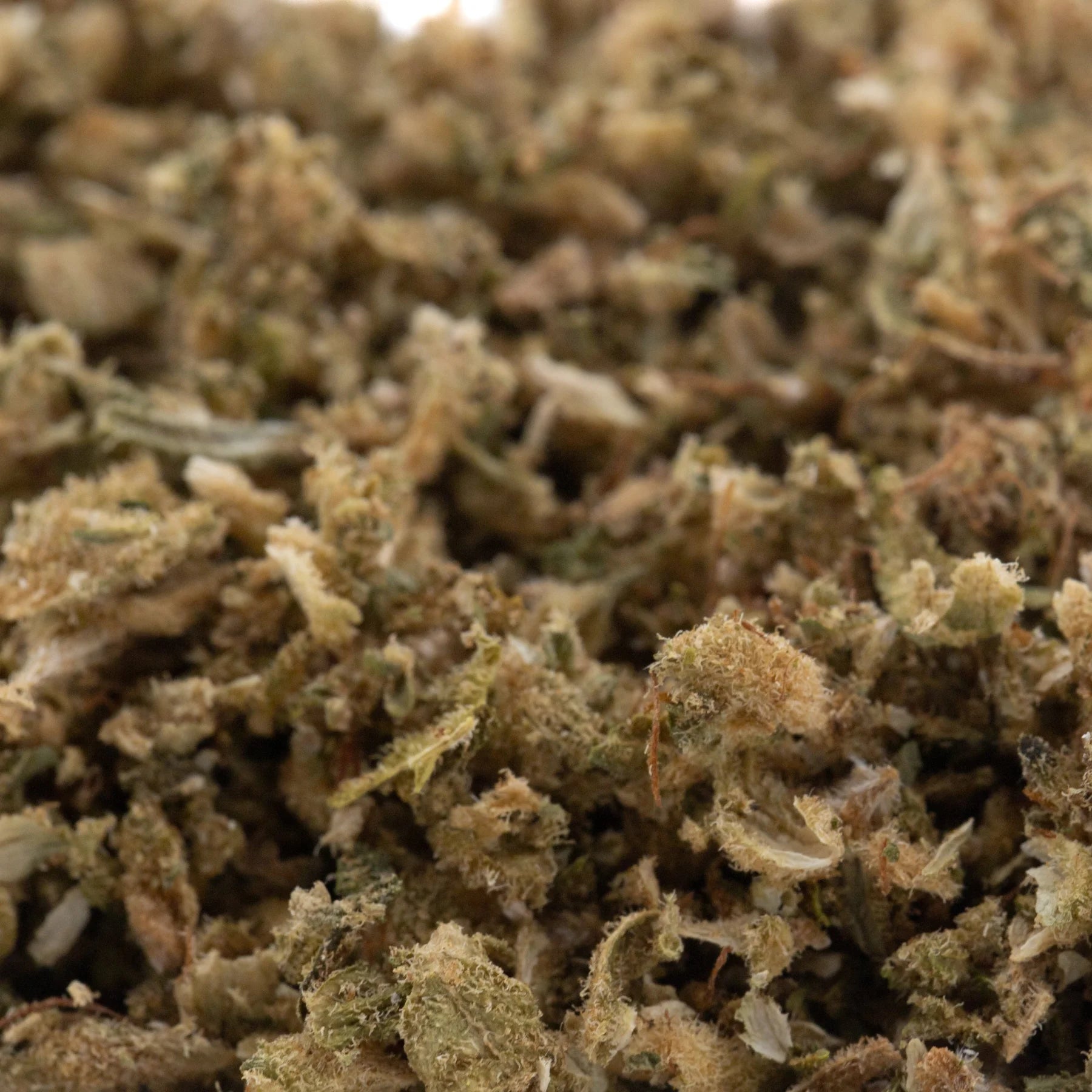 A pile of rna cbd hemp flower trim with green and brown dried buds covered in fine trichomes highlighting the terpene profile