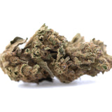 A dense royal highness hemp flower bud with green and brown hues covered in fine lab tested trichomes