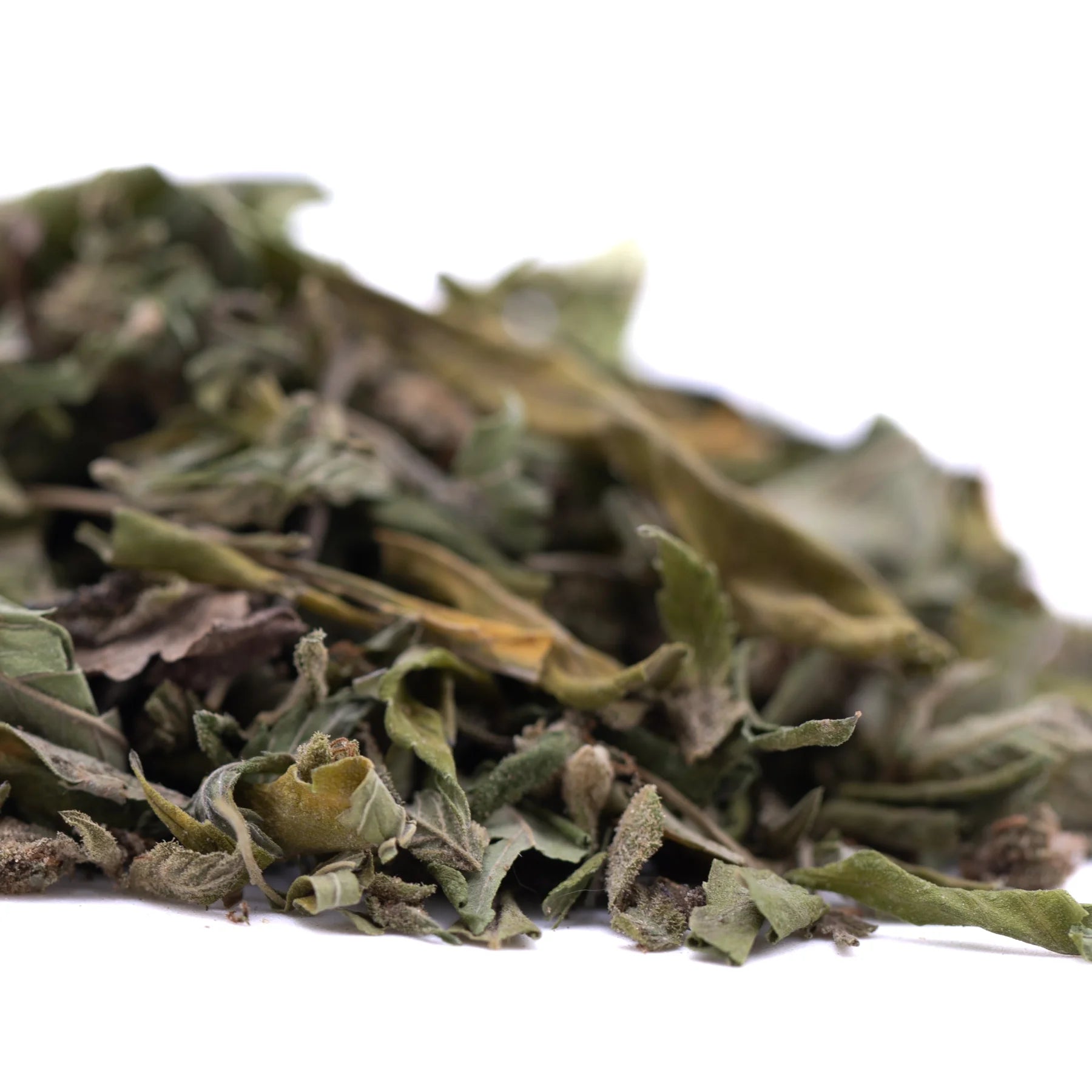 A pile of dried rozay cake greenhouse thca trim wholesale hemp flower leaves in green and brown hues