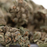 Sour Apple THCa Flower Smalls: Potent bud with green leaves and white trichomes