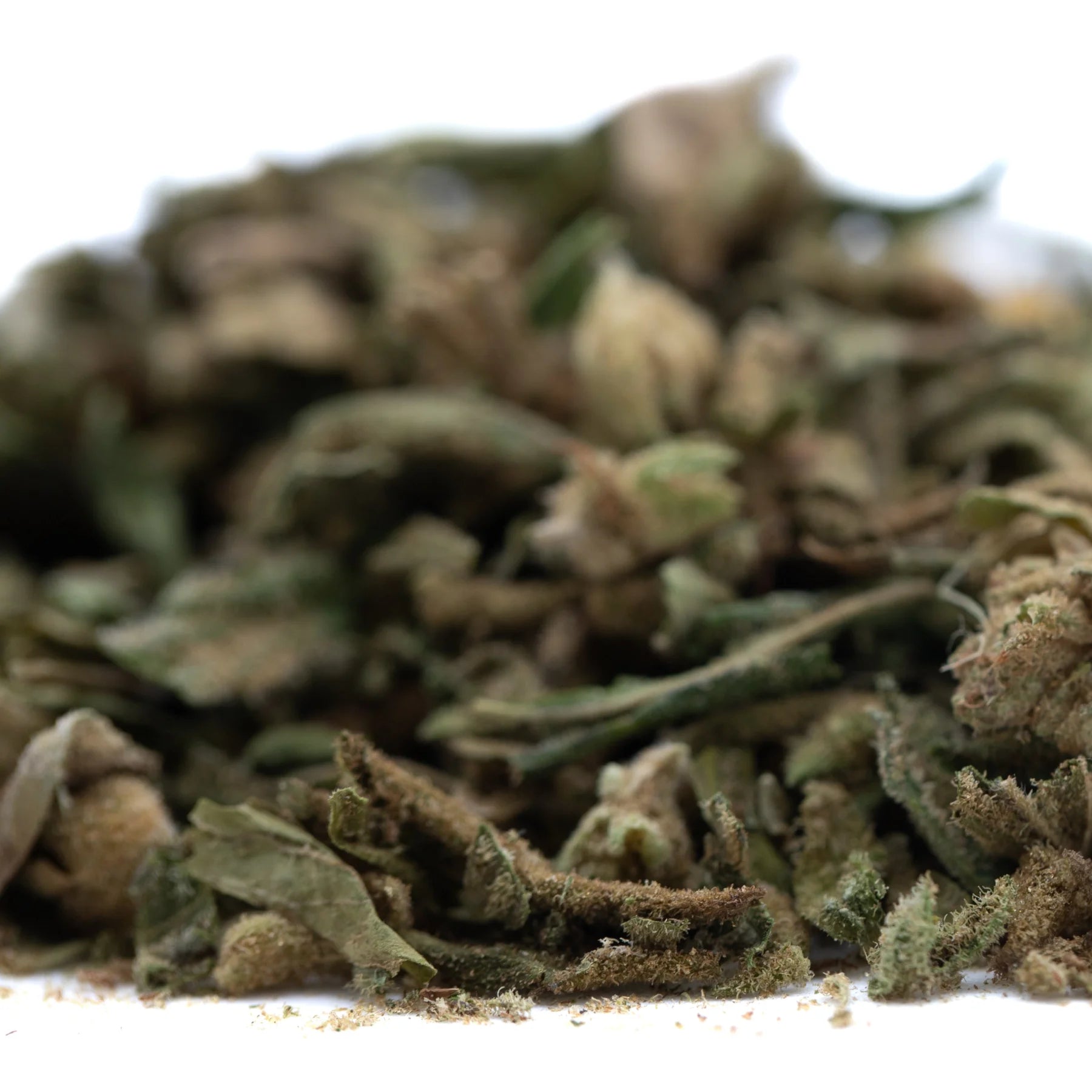 A pile of green and brown sour diesel thca trim wholesale cannabis buds with textured trichome-covered hemp flower surface