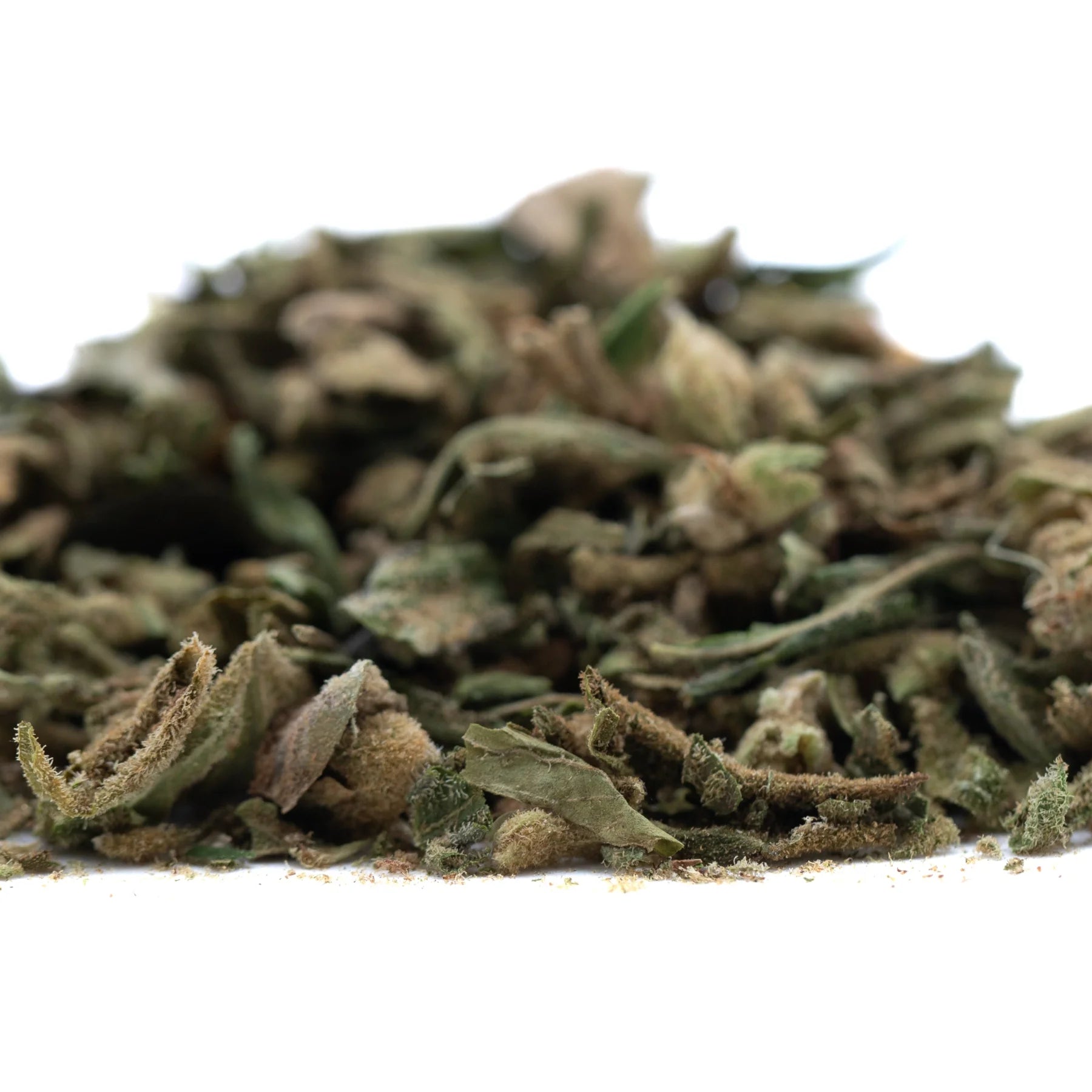 A pile of dried sour diesel thca trim wholesale leaves with green and brown hues and a slightly fuzzy texture for hemp flower