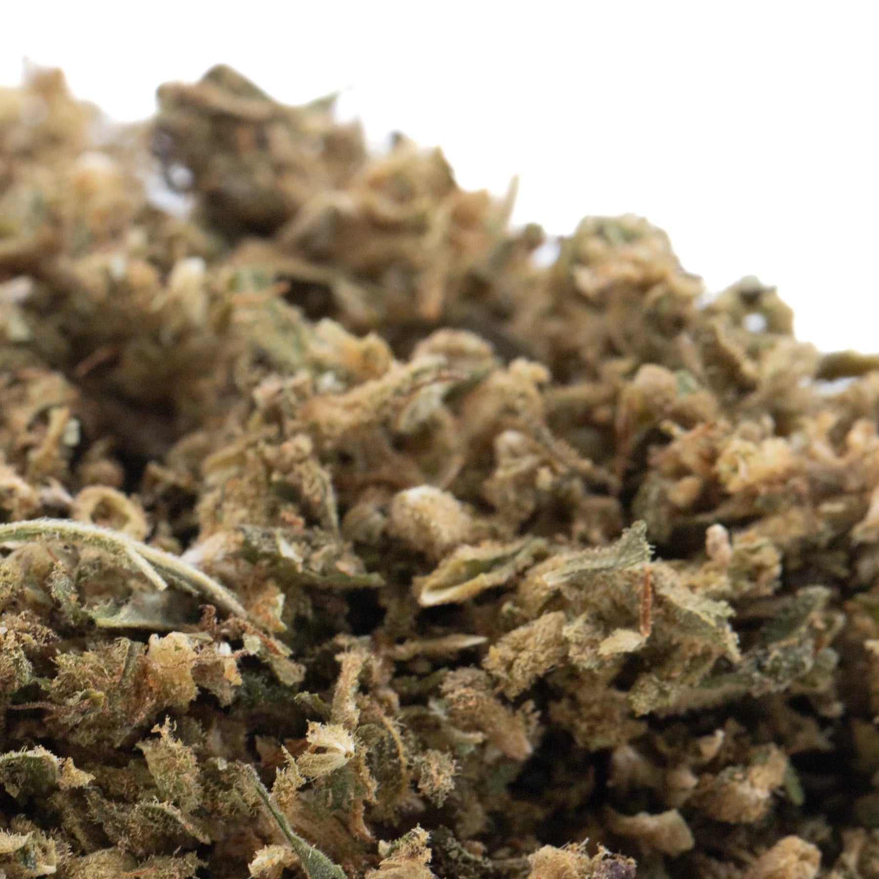 A dense pile of sour hawaiian cbd trim hemp flower with green and brown hues in sour hawaiian haze full-term trim