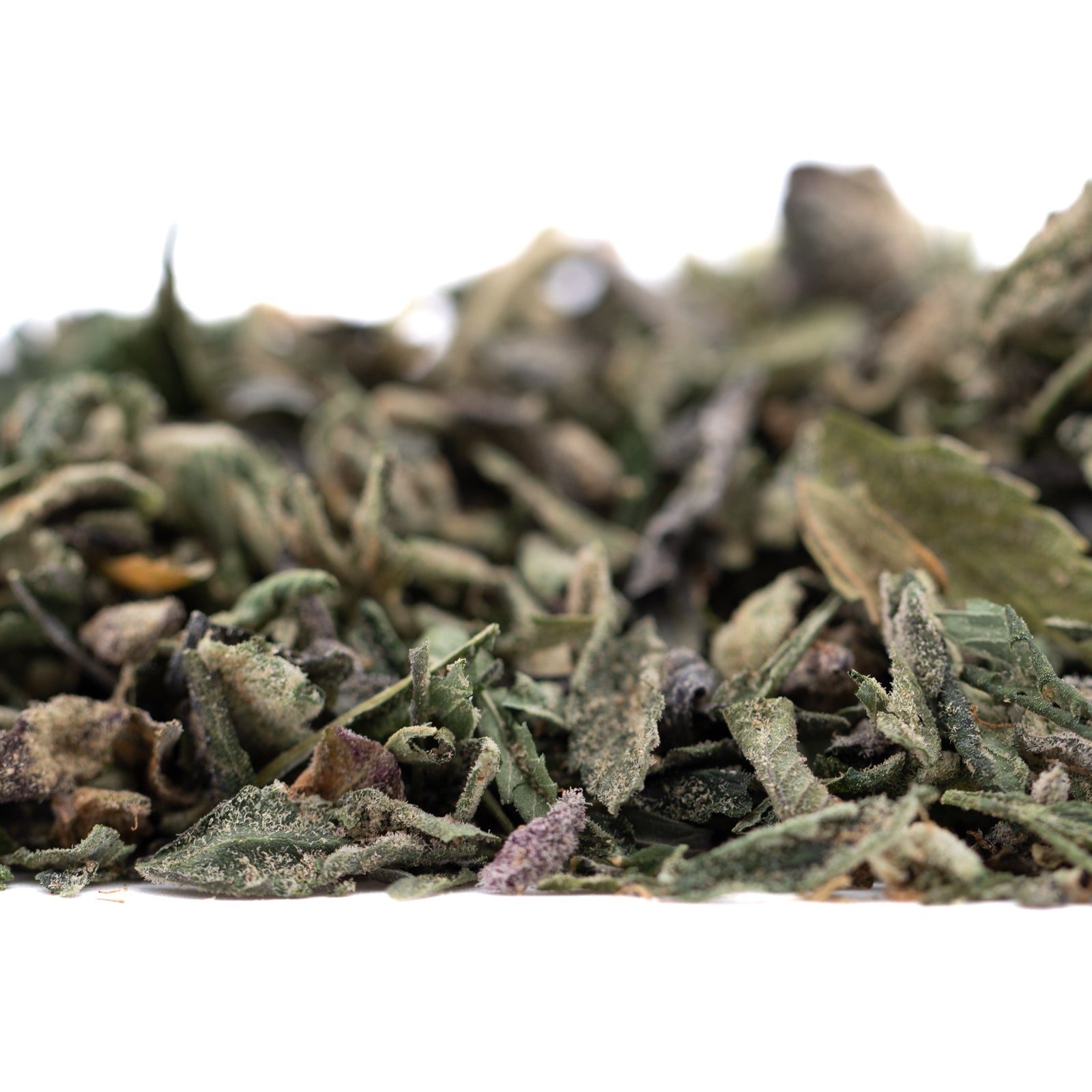 Organic Sour OG THCa trim wholesale with green leaves and dried herbs