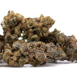 A dense resinous space candy indoor thca flower bud with green and brown hues covered in trichomes