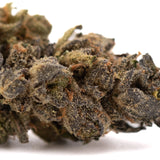 A dense resinous space candy indoor hemp flower bud with trichomes and orange pistils for social anxiety relief