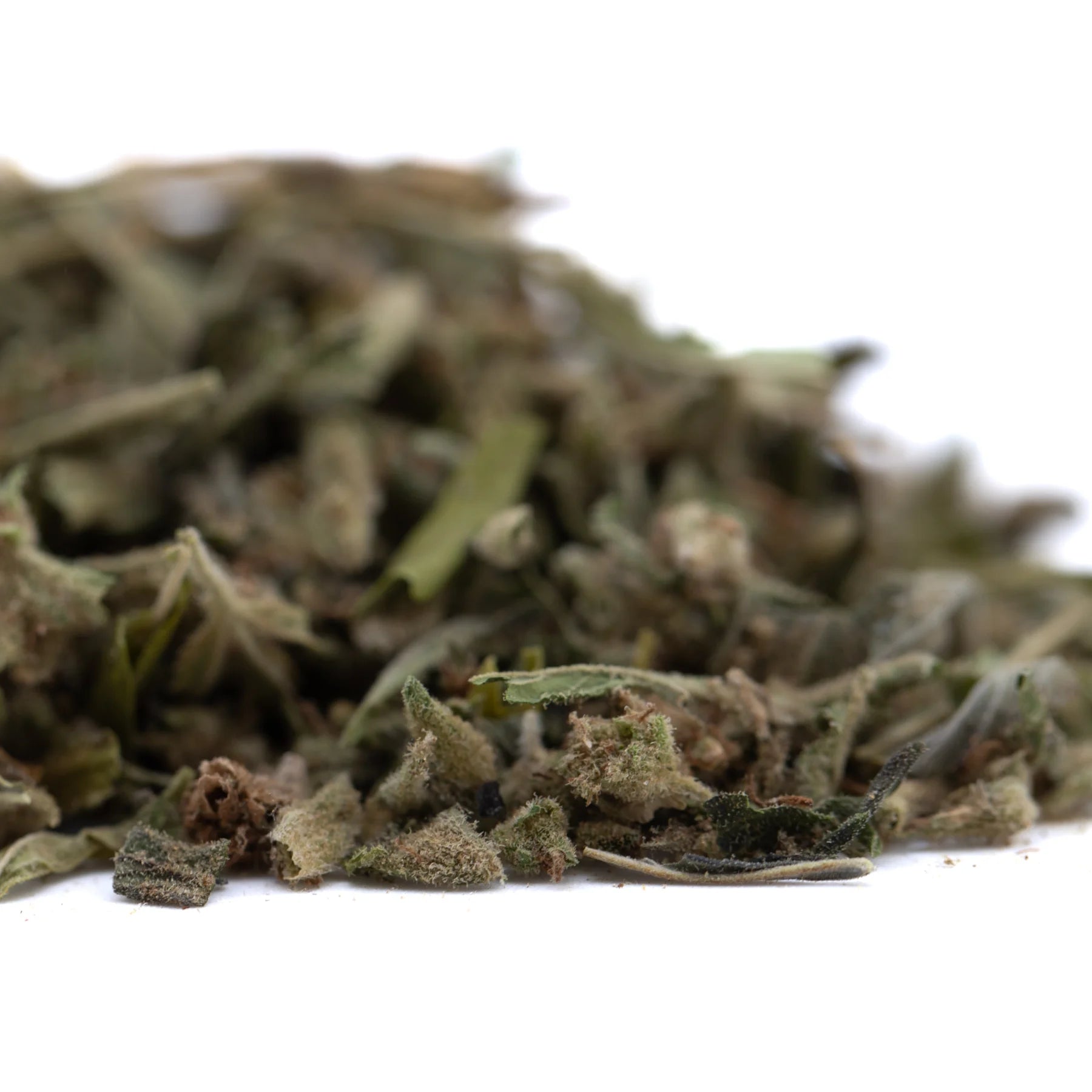 A pile of dried crumbled sage leaves in muted green and brown hues for strawberry cheesecake thca trim wholesale premium flower