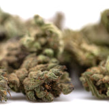 Green and brown strawberry cheesecake small thca flower buds with dense frosty texture in hemp flower form