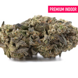 A dense street guru indoor thca hemp flower bud with green and purple hues covered in fine trichomes