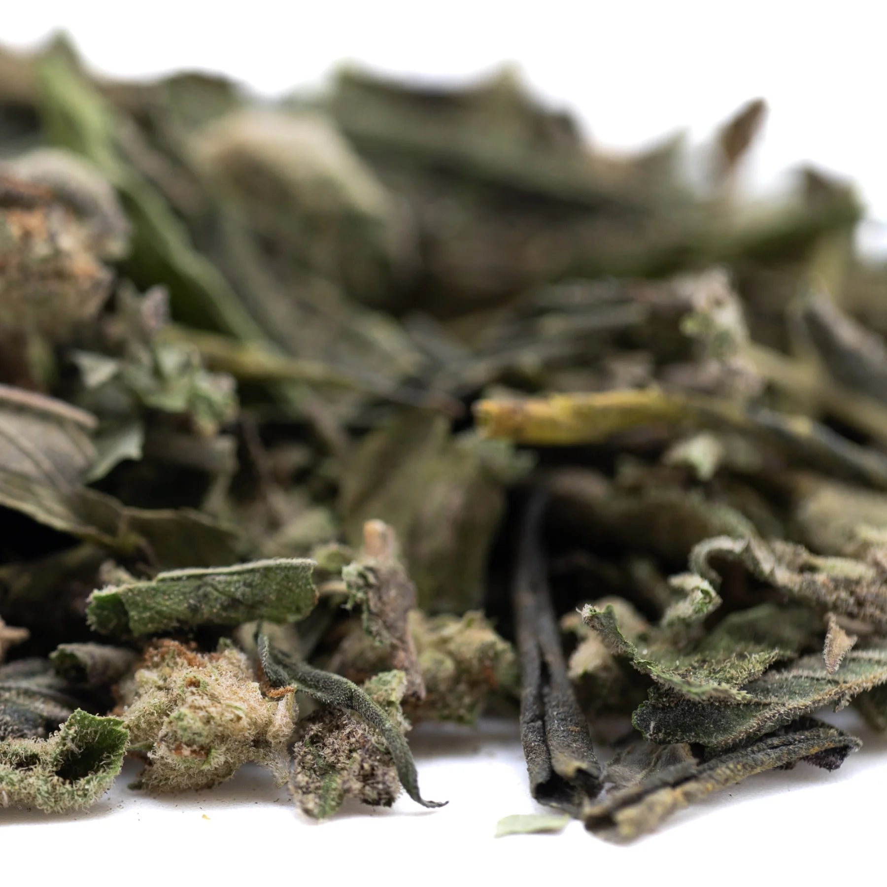 Dried green thca trim with fuzzy texture and brownish stems from subzero greenhouse for chronic pain relief and therapeutic effects