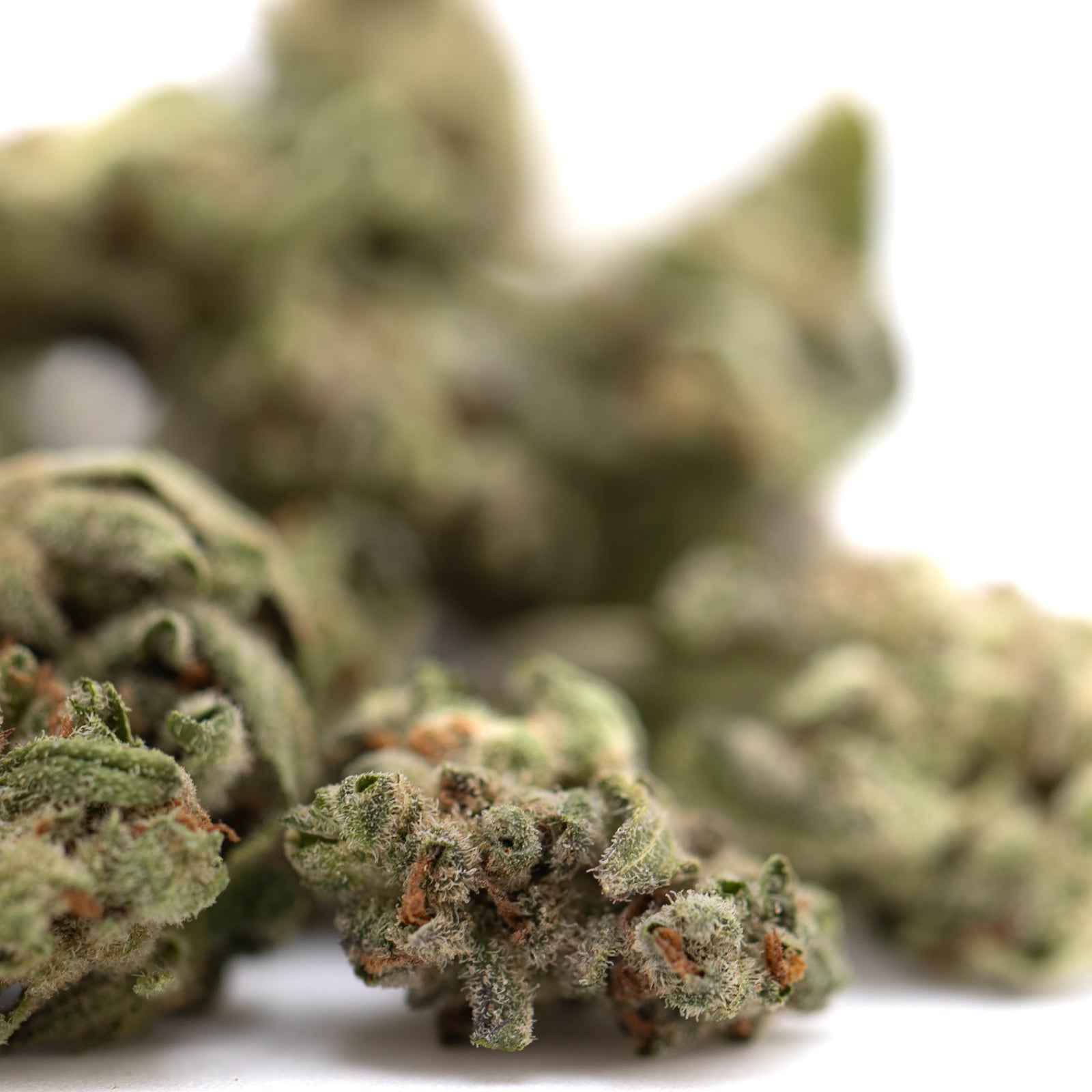 Top Gun THCa Flower Smalls: Marijuana bud with green leaves and orange trichomes