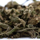 A pile of tricross full-term thca dried cannabis buds with green and brown hues covered in fine trichomes for wholesale