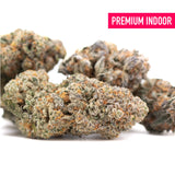Premium tropical punch indoor THCa flower with dense frosty buds in vibrant green orange and purple hues, ideal for skunk x haze fans