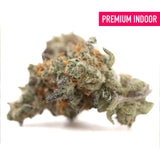 A dense frosty green truffle dawg thca flower hemp bud with orange pistils and textured surface