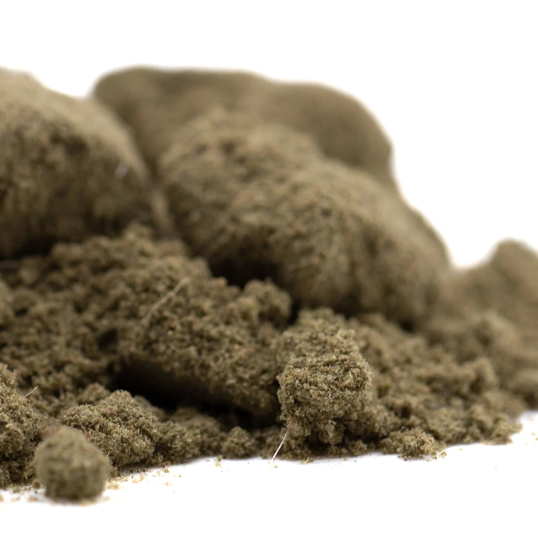 A mound of coarse earthy brown thca kief with fibrous texture from turtle taffy hemp flower product