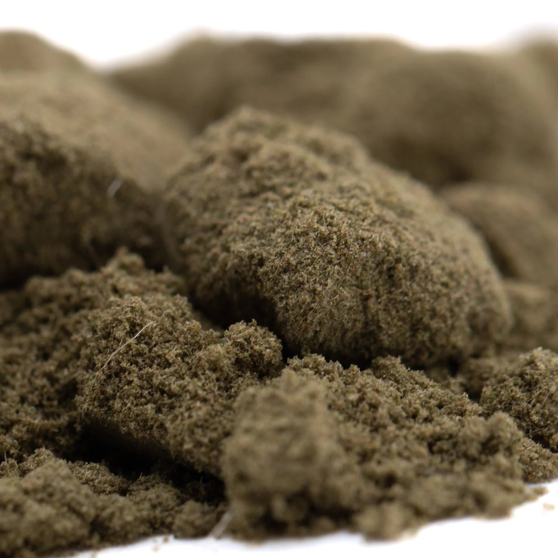 A mound of coarse earthy-brown thca kief from turtle taffy hemp flower with a textured granular surface