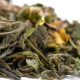 A pile of dried zkittlez cross greenhouse thca trim leaves with tropical citrus and candy-sweet flavor notes