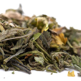 A pile of dried green and yellow zkittlez cross greenhouse thca trim leaves with tropical citrus candy-sweet flavor